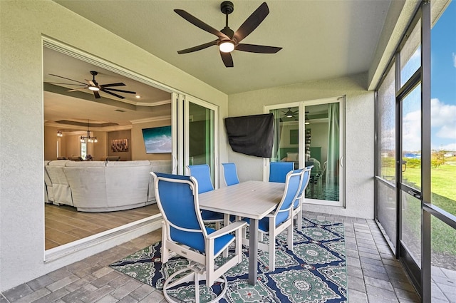 sunroom with a raised ceiling and ceiling fan