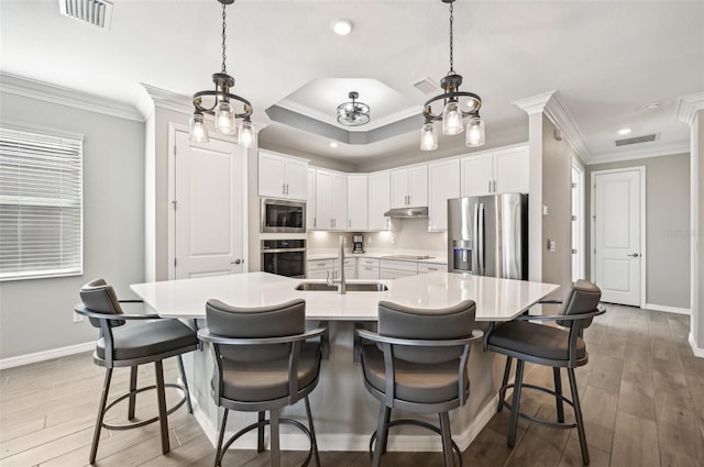 kitchen with hardwood / wood-style flooring, appliances with stainless steel finishes, sink, and white cabinets