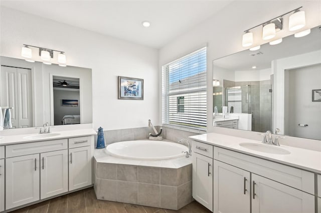 bathroom featuring vanity, wood-type flooring, separate shower and tub, and ceiling fan