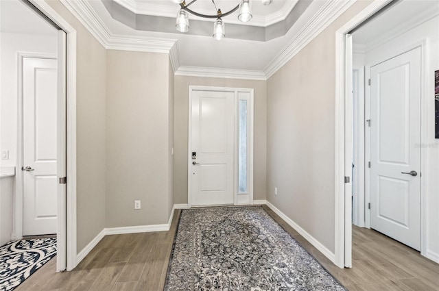 entryway featuring light hardwood / wood-style flooring, crown molding, and a notable chandelier