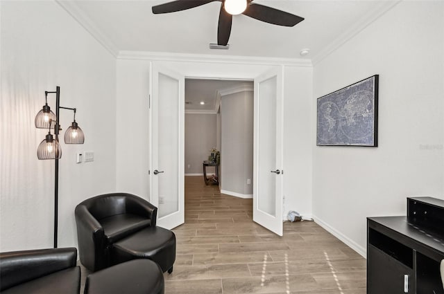 living area with crown molding, french doors, light hardwood / wood-style floors, and ceiling fan