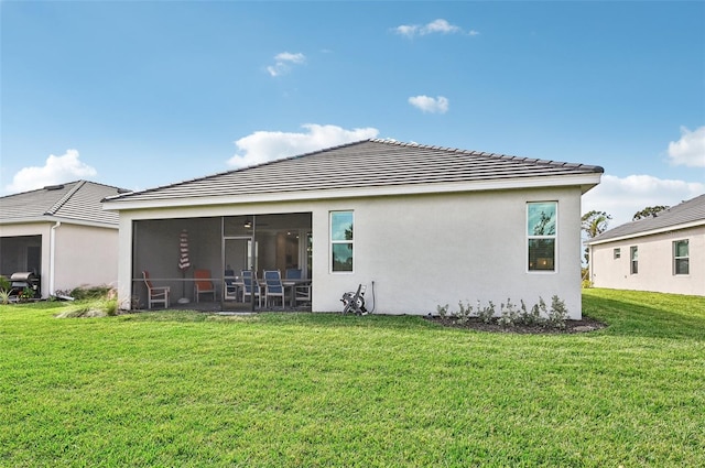 rear view of property with a yard and a sunroom