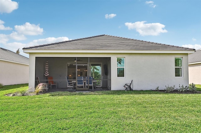 rear view of property featuring a sunroom and a lawn