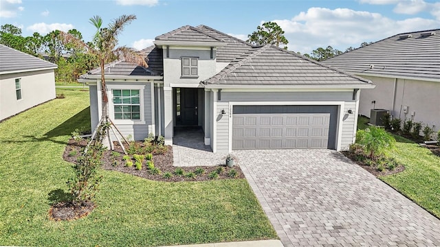 view of front of property with a garage, a front lawn, and central air condition unit