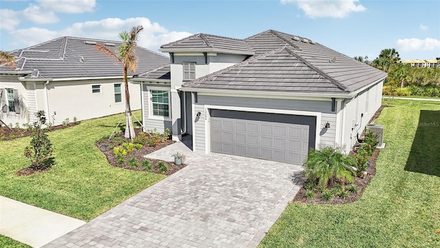 view of front of property featuring a front lawn, central AC, and a garage