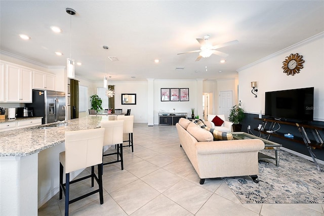 living room with crown molding, light tile patterned floors, and ceiling fan