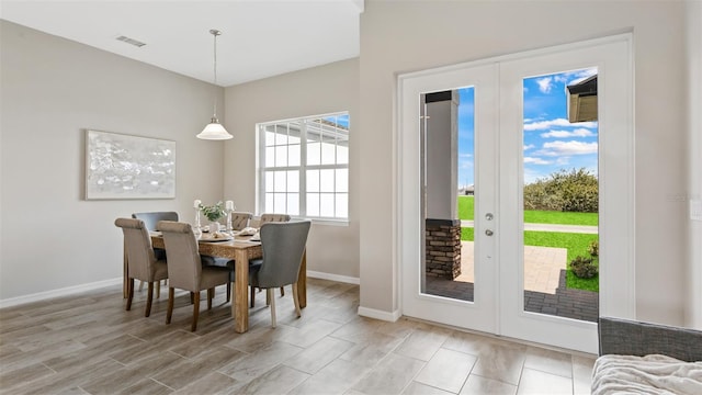 dining room with light hardwood / wood-style floors and french doors