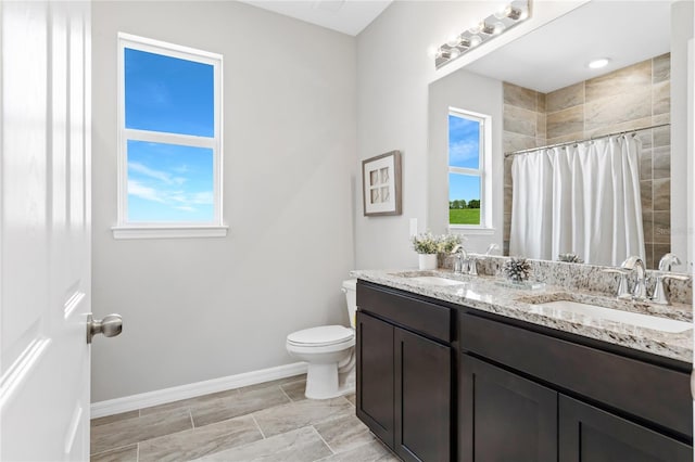 bathroom featuring vanity, curtained shower, toilet, and plenty of natural light