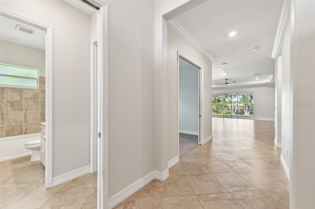 corridor featuring ornamental molding, light tile patterned floors, and plenty of natural light