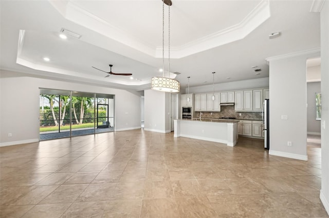 unfurnished living room with ceiling fan, crown molding, and a tray ceiling