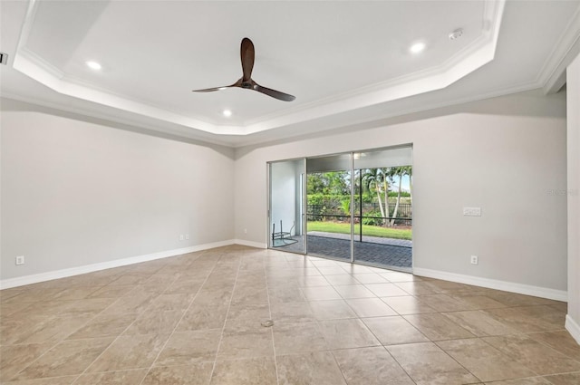 spare room featuring crown molding, ceiling fan, and a raised ceiling