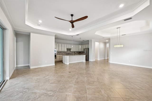 unfurnished living room featuring ceiling fan, a raised ceiling, and ornamental molding