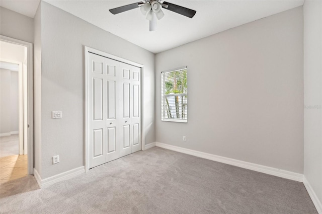 unfurnished bedroom with a closet, ceiling fan, and light colored carpet