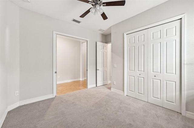 unfurnished bedroom with light carpet, a closet, and ceiling fan