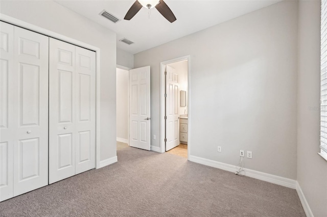 unfurnished bedroom featuring connected bathroom, light carpet, a closet, and ceiling fan