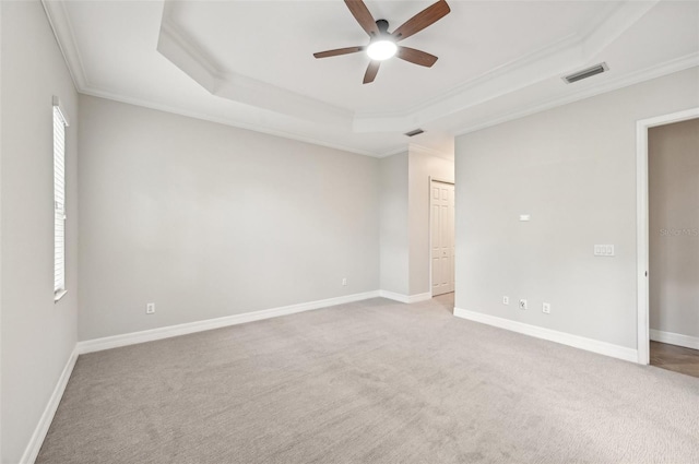 unfurnished bedroom with crown molding, carpet floors, ceiling fan, and a raised ceiling