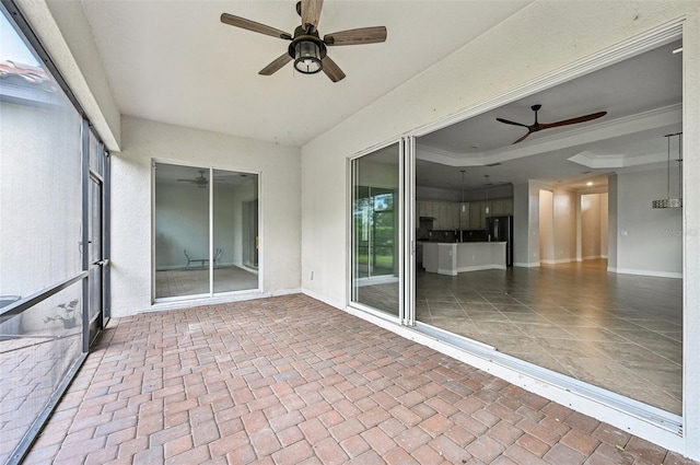 unfurnished sunroom featuring ceiling fan