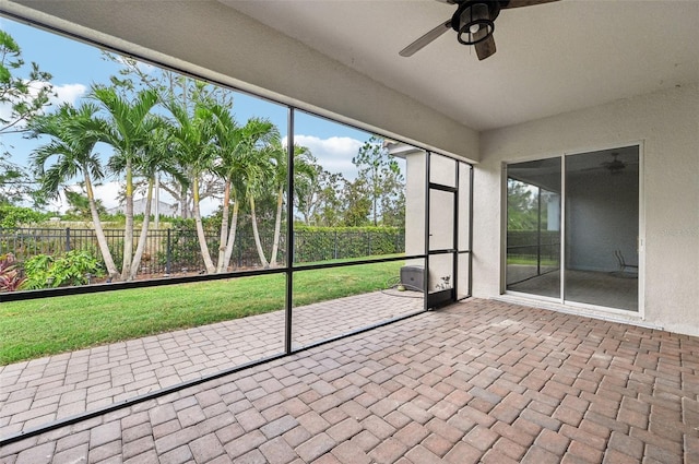 unfurnished sunroom featuring ceiling fan