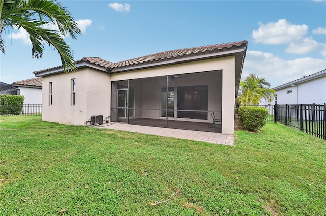 back of house with a patio, a sunroom, a lawn, and central air condition unit