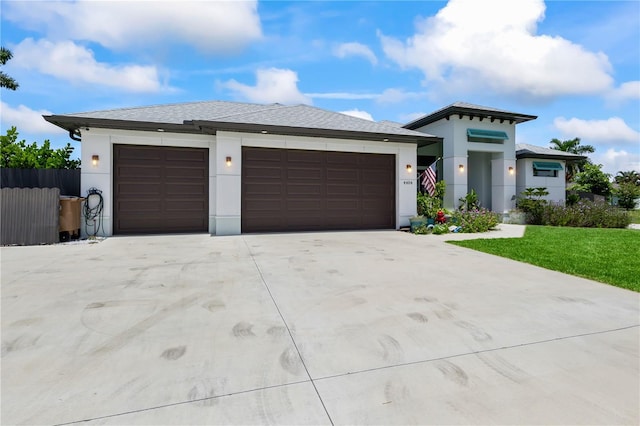 prairie-style home featuring a front yard and a garage