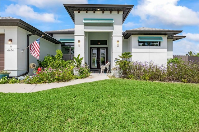 view of exterior entry with french doors and a yard