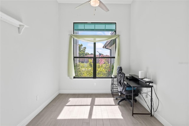 office with light wood-type flooring and ceiling fan