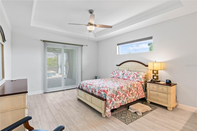 bedroom featuring multiple windows and a raised ceiling