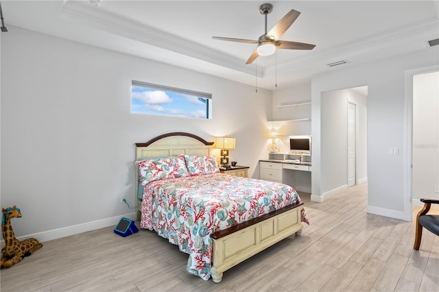 bedroom featuring ornamental molding, a tray ceiling, light wood-type flooring, and ceiling fan