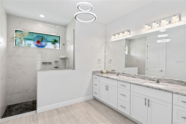 bathroom featuring a tile shower, hardwood / wood-style floors, and vanity