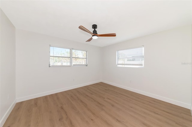 spare room with light hardwood / wood-style floors, a healthy amount of sunlight, and ceiling fan