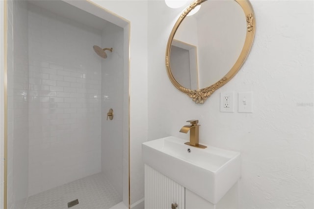 bathroom with sink and tiled shower