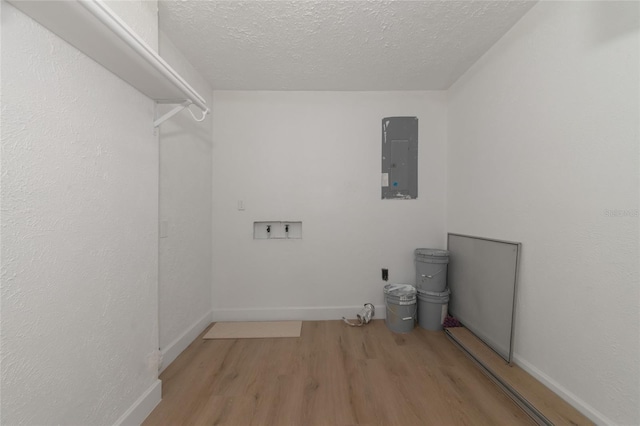 laundry room with electric panel, a textured ceiling, washer hookup, and light hardwood / wood-style floors