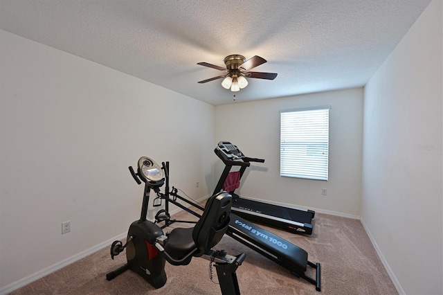 exercise room with a textured ceiling, light colored carpet, and ceiling fan