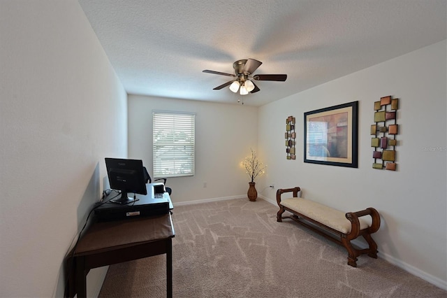 living area featuring ceiling fan, light colored carpet, and a textured ceiling