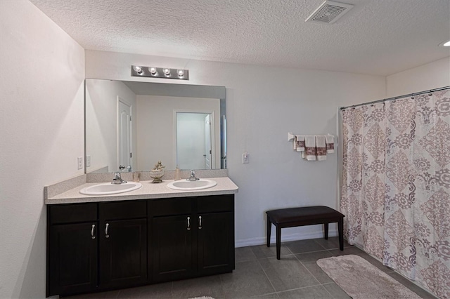 bathroom featuring vanity, a textured ceiling, and tile patterned floors