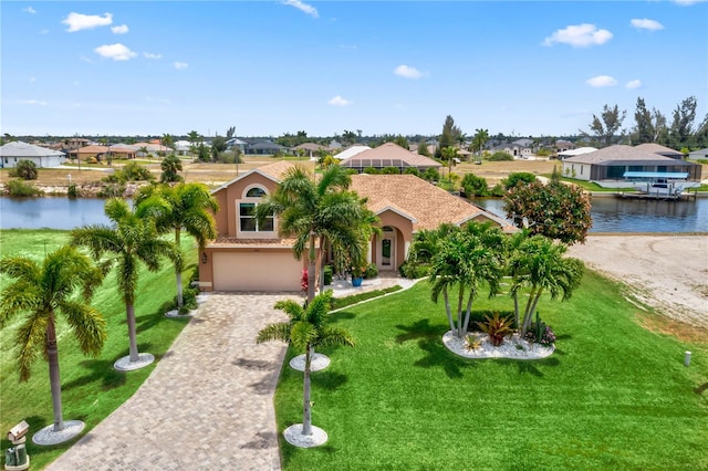 mediterranean / spanish house with a front yard, a garage, and a water view