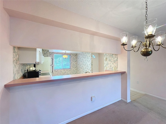 kitchen featuring kitchen peninsula, hanging light fixtures, carpet floors, and white refrigerator