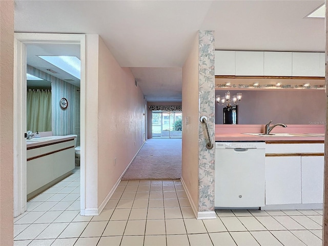 kitchen featuring white cabinetry, dishwasher, light colored carpet, and sink