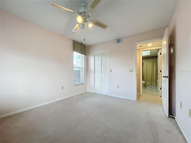 unfurnished bedroom with light carpet, a closet, and ceiling fan