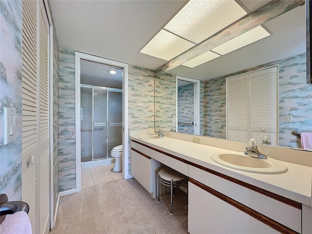 bathroom with vanity, toilet, a shower with shower door, and tile patterned flooring