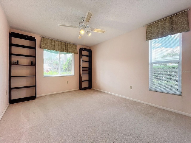 carpeted empty room with a textured ceiling and ceiling fan