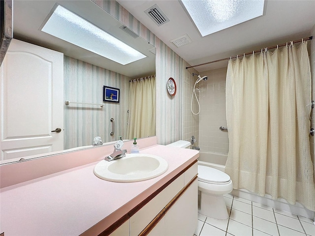 full bathroom with tile patterned floors, shower / bathtub combination with curtain, toilet, vanity, and a skylight