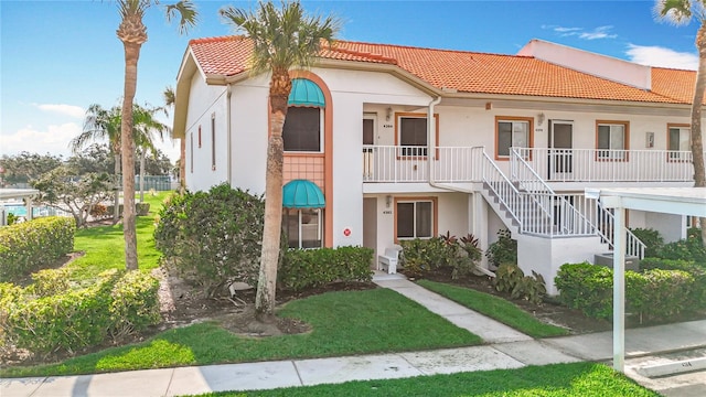 4382 Madeira Ct Unit 3361, Sarasota, FL 34233 - townhome / multi-family property featuring a tile roof, stucco siding, a porch, and stairway