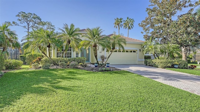 21 Bayhead Ln, Osprey, FL 34229 - mediterranean / spanish-style house featuring stucco siding, an attached garage, decorative driveway, and a front lawn