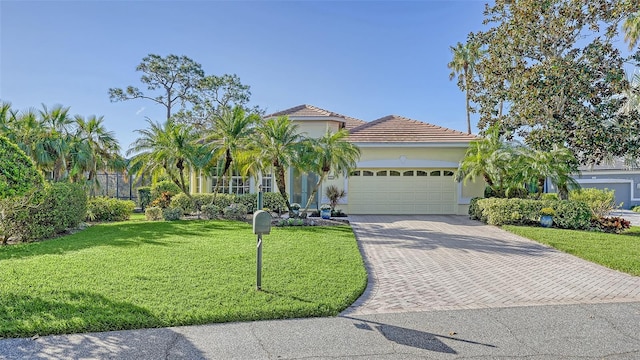 21 Bayhead Ln, Osprey, FL 34229 - view of front of home featuring a garage, decorative driveway, a front yard, stucco siding, and a tile roof