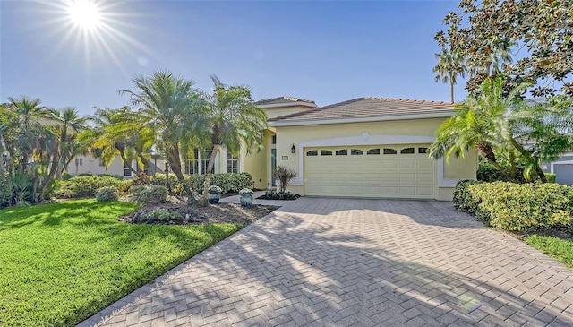 21 Bayhead Ln, Osprey, FL 34229 - view of front facade featuring an attached garage, a front lawn, decorative driveway, and stucco siding