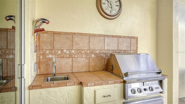 21 Bayhead Ln, Osprey, FL 34229 - kitchen with a sink, a textured wall, tile counters, and backsplash