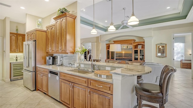 21 Bayhead Ln, Osprey, FL 34229 - kitchen featuring a sink, stainless steel appliances, beverage cooler, light tile patterned floors, and a breakfast bar area
