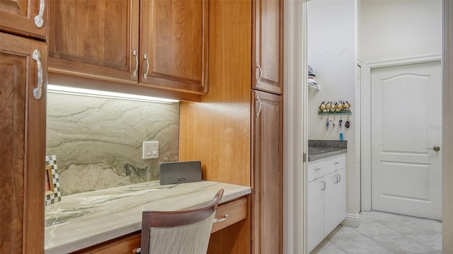 21 Bayhead Ln, Osprey, FL 34229 - kitchen with light tile patterned flooring, brown cabinets, light countertops, and tasteful backsplash