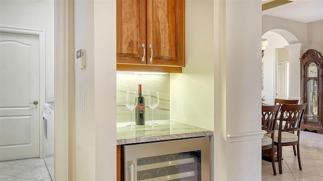 21 Bayhead Ln, Osprey, FL 34229 - indoor dry bar featuring wine cooler, arched walkways, light tile patterned flooring, and washer / clothes dryer